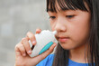 An Asian kid use nasal sray for rhinitis
