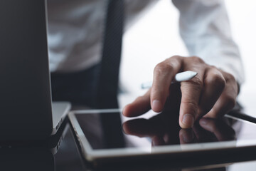 Poster - Businessman using digital tablet and working on laptop computer in office