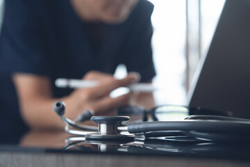 Wall Mural - Male doctor working on laptop computer in medical office