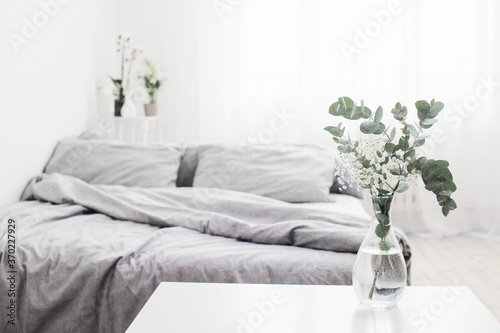 eucalyptus in glass vase in white bedroom