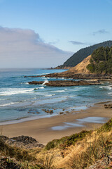 Wall Mural - Vertical Image-Waves break on a sandy beach and rugged hills along the Oregon coast