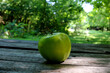 Fresh green apple on wooden surface with grunge texture, close up