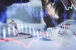 © peshkova - Double exposure of forex graph sketch hologram and woman holding and using a mobile device. Stock market concept.