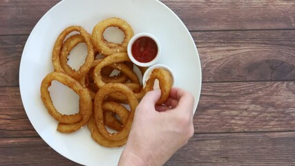 Canvas Print - Dipping an Onion ring into Sauce