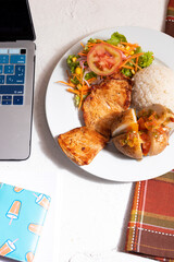 Wall Mural - Plato de almuerzo casero con pollo, papa arroz y ensalada. Plato tradicional colombiano para comer en casa en teletrabajo.