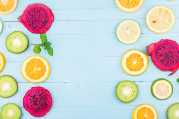 Poster - Fruit background. Colorful fresh fruit on Blue wooden board. Orange, Dragon fruit,  lemon，Flat lay, top view,