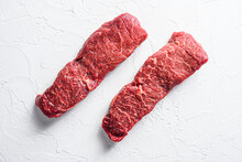 Raw Set Of Denver Steak On A White Stone Background Top View
