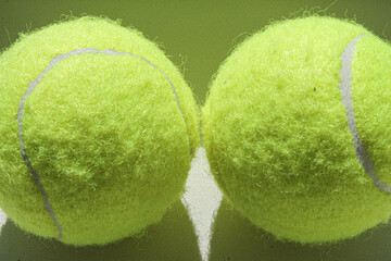 Two golden tennis balls on a white background