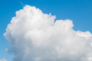 Blue skies on a clear day. White cumulus clouds float across the sky.