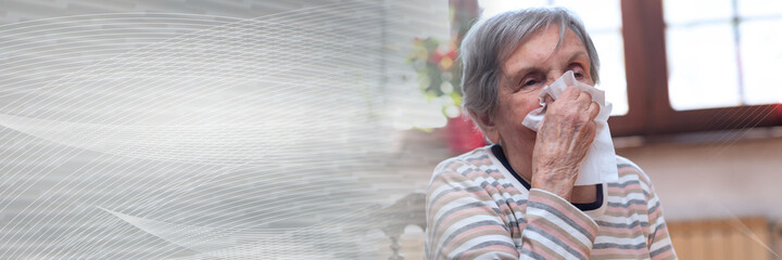 Old woman blowing her nose; panoramic banner