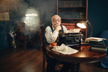 Elderly Writer Works On Vintage Typewriter