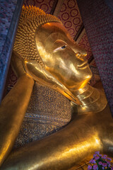 Bangkok, Thailand - August 14, 2020: Giant reclining Buddha on the famous Buddhist temple Wat Pho. Bangkok, Thailand.