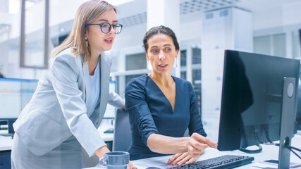 Aufkleber - In the Busy Corporate Office: Female Manager Explains Task to Businesswoman who Works on Desktop Computer. Businesspeople an Working with Clients, Having Discussions and Analysing Statistics