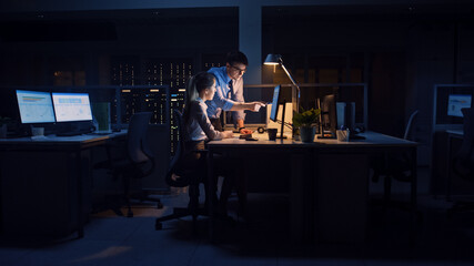 Aufkleber - Confident Businessman Uses Desktop Computer, His Female Project Manager Explains Specific Tasks, Account Handling and Strategic Moves. Professional People Late at Night in Big Corporate Office