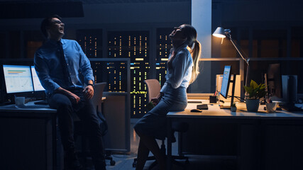 Aufkleber - Late at Night in the Corporate Office Two Young Professionals Chatting Friendly, Exchanging News, Talking about Job, Flirting