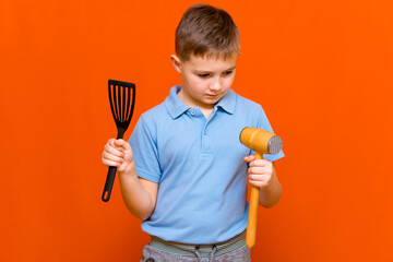 professional youn boy kid chef on orange background.housewifes Green concept.