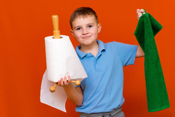 Portrait of a Caucasian boy. The boy holds a paper towel, the other hand used to towel. Housewives concept.