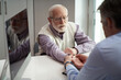 © Yakobchuk Olena - Elderly man having his wrist tendons examined by a doctor