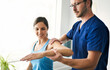 © Louis-Paul Photo - Male Physical Therapist Stretching a Female Patient Slowly.