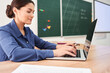 © Yakobchuk Olena - Smiling elegant woman using laptop in class room