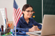 © Yakobchuk Olena - Cheerful english tutor having online lesson at school