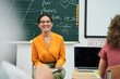 © Yakobchuk Olena - Happy female teacher using notebook at lesson