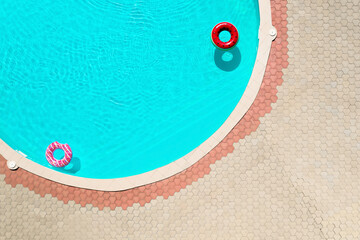 Poster - Inflatable rings floating in swimming pool, top view. Summer vacation