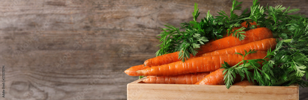 Crate of fresh carrots on wooden background, closeup with space for text. Banner design - obrazy, fototapety, plakaty 