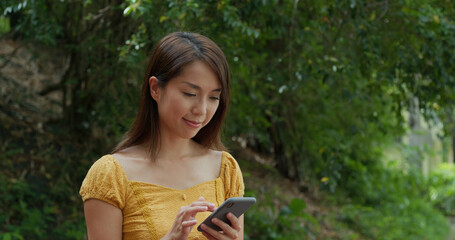 Poster - Woman use of mobile phone in city park