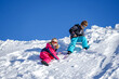 © Elena - Two joyful kids playing on the snowing mountain on a winter day. Brother and sister