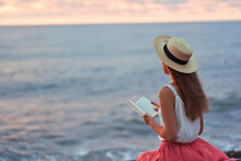 Dreaming Serene Romantic Woman Reading Novel Book On The Seashore And Enjoying A Happy Moment And A Calm