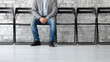 © fizkes - Cropped image closeup legs of confident man candidate waiting for job interview, searching work, businessman applicant sitting on chair in empty office hall, recruitment and employment concept