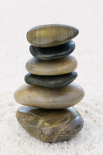 Stack Of Balanced Polished Rocks On White Quartz Pebbles To Aid Zen Contemplation