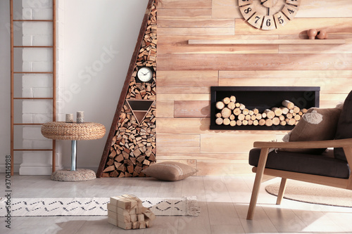 Fotografía Decorative fireplace with stacked wood in cozy living room interior