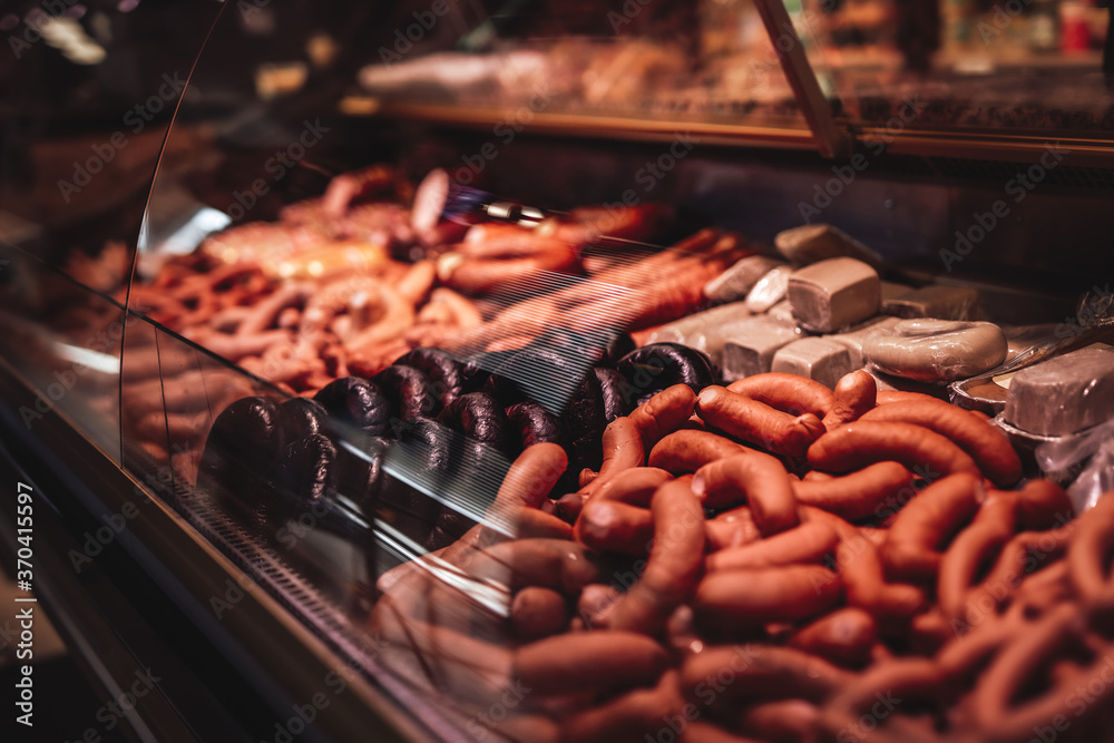 Many sausages in the butcher shop. Smoked meat assortment with huge choise. Sausage sale. - obrazy, fototapety, plakaty 