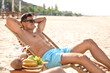 © New Africa - Happy man resting on sunny beach at resort