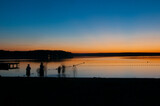 Fototapeta Fototapety pomosty - Zachód słońca nad jeziorem - kapiący się ludzie - długa ekspozycja