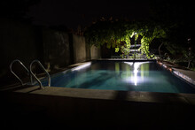 Pool And Waterfall At Night - Vacation Background. Colorful Light Decoration. Freezelight