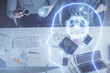 © peshkova - Double exposure of man and woman working together and human brain hologram drawing. Brainstorm concept. Computer background. Top View.