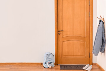 Poster - Door mat with backpack and shoes on floor in hallway