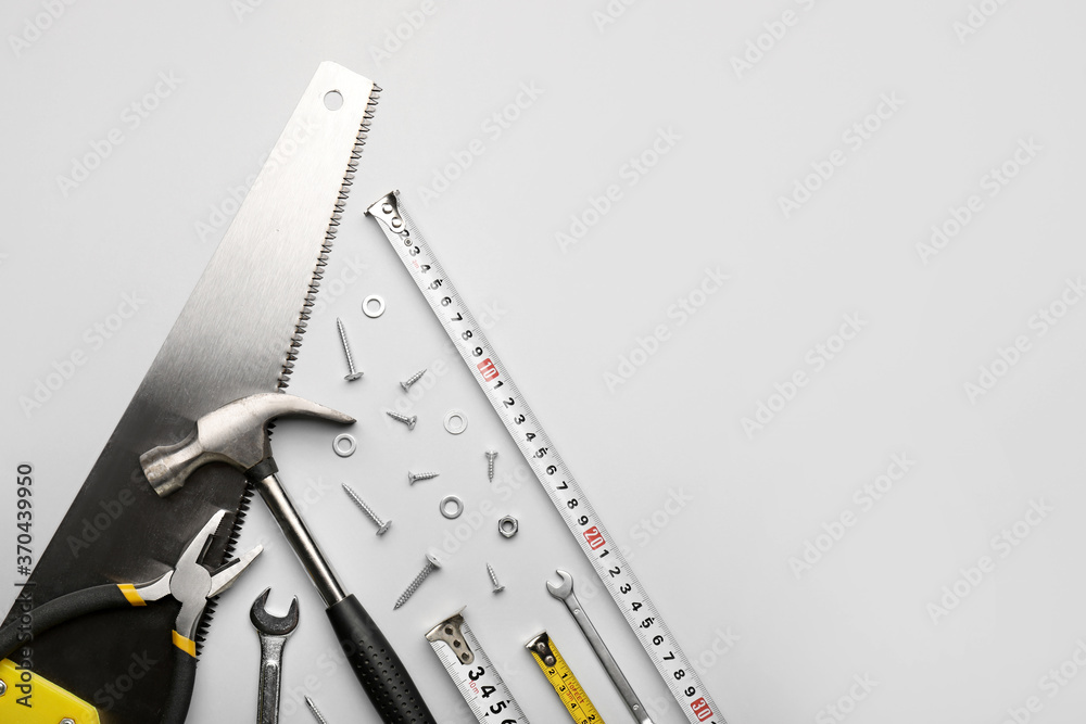 Measuring tapes with builder's supplies on white background