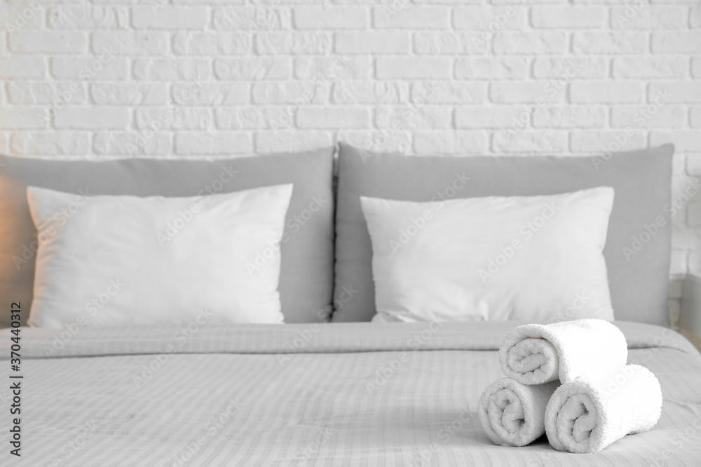 Clean towels on bed in hotel room