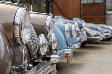 Selected focus at detail of headlight, grille and hood of group old classic and vintage luxury car.