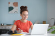 © Pixel-Shot - Young woman using laptop for online learning at home