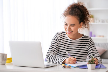 young woman using laptop for online learning at home