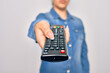 © Krakenimages.com - Woman changing television channel holding tv remote control. Standing over isolated white background