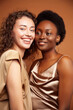© iordani - two pretty girls african and caucasian blond posing cheerful together on brown background, ethnicity diverse lifestyle people concept