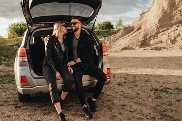 Happy Young Traveler Couple Dressed Alike in Black Leather and Jeans Jacket Having Fun Time on Road Trip Outside the City