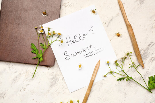 Paper sheet with text HELLO SUMMER and pens on white background