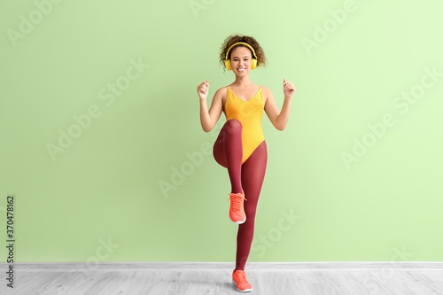 Fotografía Young woman doing aerobics on color background